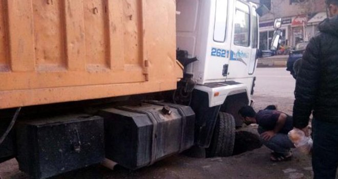 Hareket halindeki kamyon, çöken yola saplandı