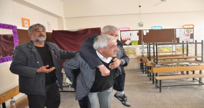 Engelli seçmen, okul görevlisinin sırtında oyunu kullandı