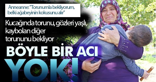 Kucağında torunu, gözleri yaşlı, kaybolan diğer torununu bekliyor