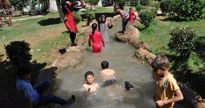 Sıcaktan bunalan çocuklar, süs havuzunda serinliyor